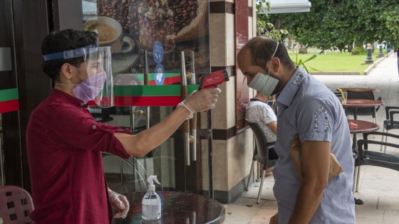 RABAT, MOROCCO - JUNE 25: A man takes a customer's temperature as he enters a cafe shop after restaurants and cafe shops reopened, which were closed within the coronavirus (Covid-19) pandemic restrictions, after the restrictions were eased in Rabat, Morocco on June 25, 2020. (Photo by Jalal Morchidi/Anadolu Agency via Getty Images)