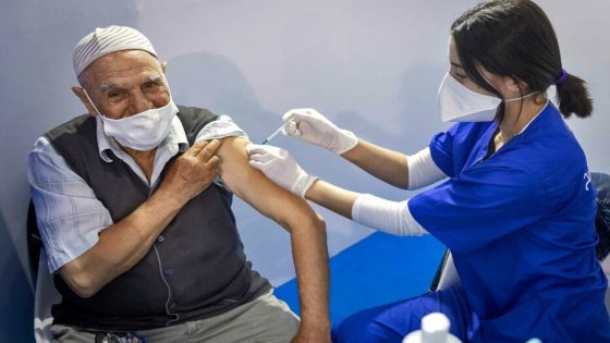 A Moroccan health worker administers a dose of the Pfizer-BioNTech COVID-19 coronavirus vaccine at a vaccination centre, in the city of Sale, on October 5, 2021. (Photo by FADEL SENNA / AFP)